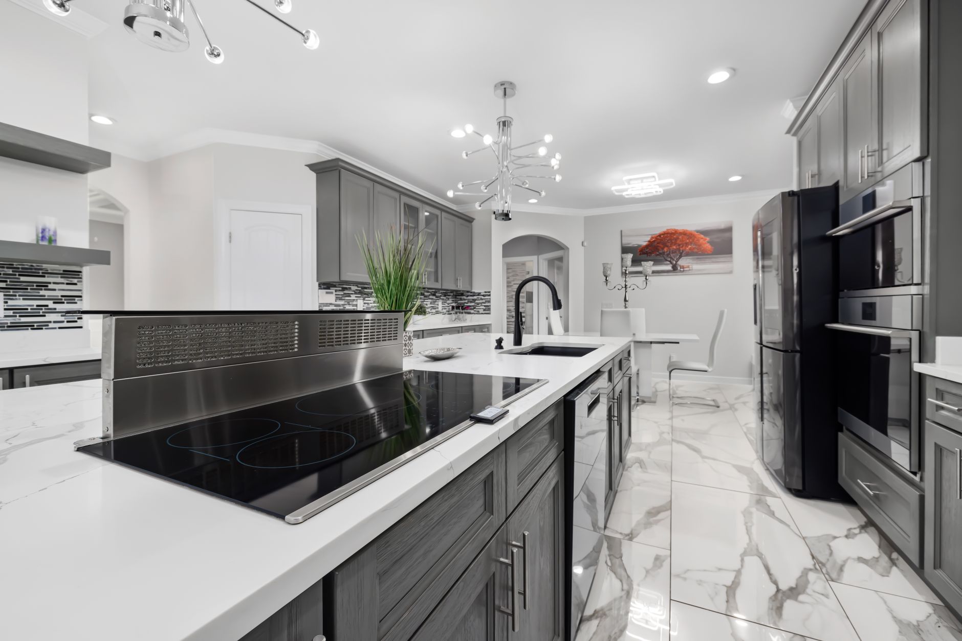 Sophisticated kitchen design featuring a sleek island, marble floors, and chic lighting in Palm Springs, CA