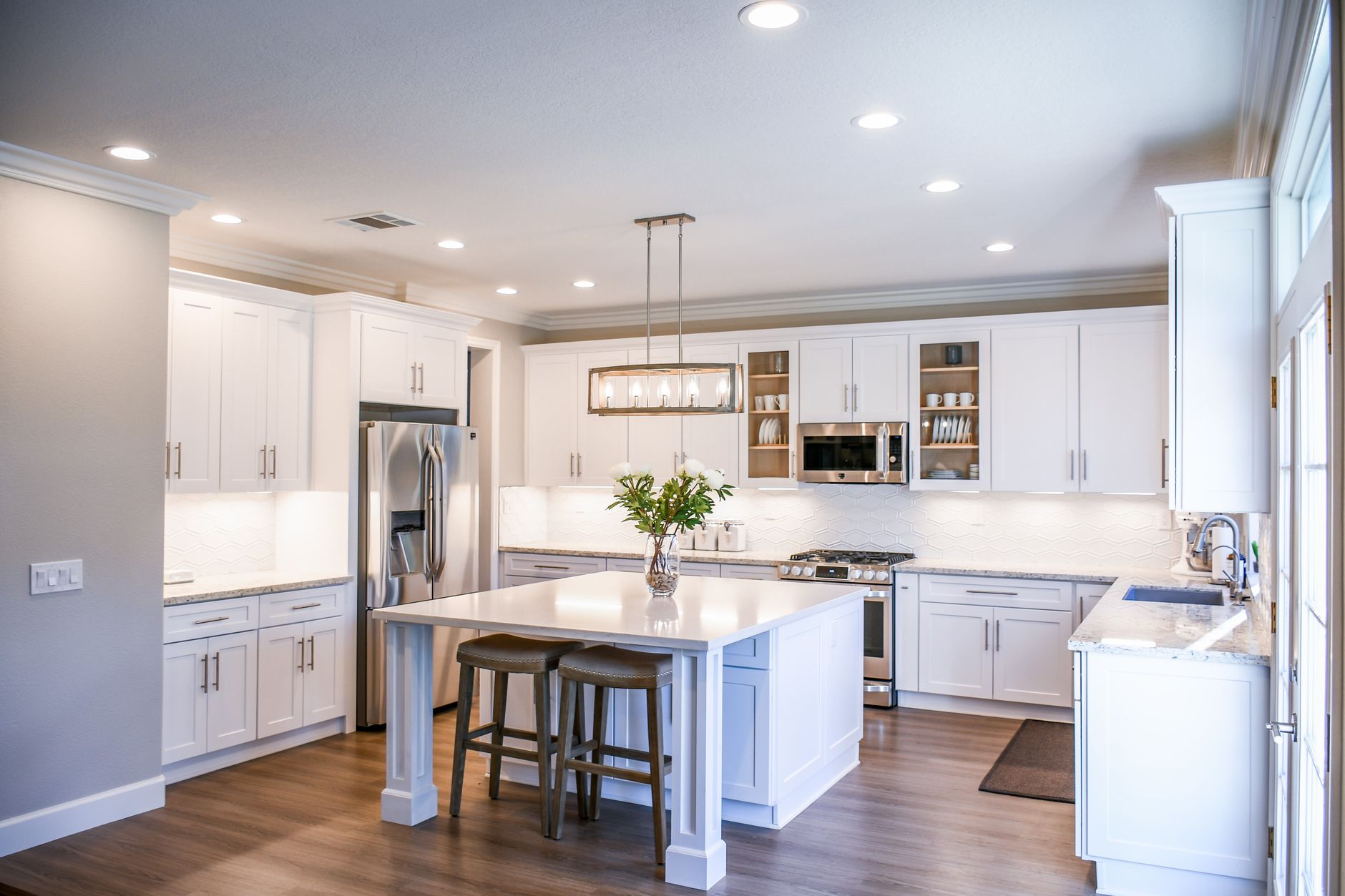 Elegant white kitchen featuring an island, modern appliances, and ample natural light in Palm Springs, CA